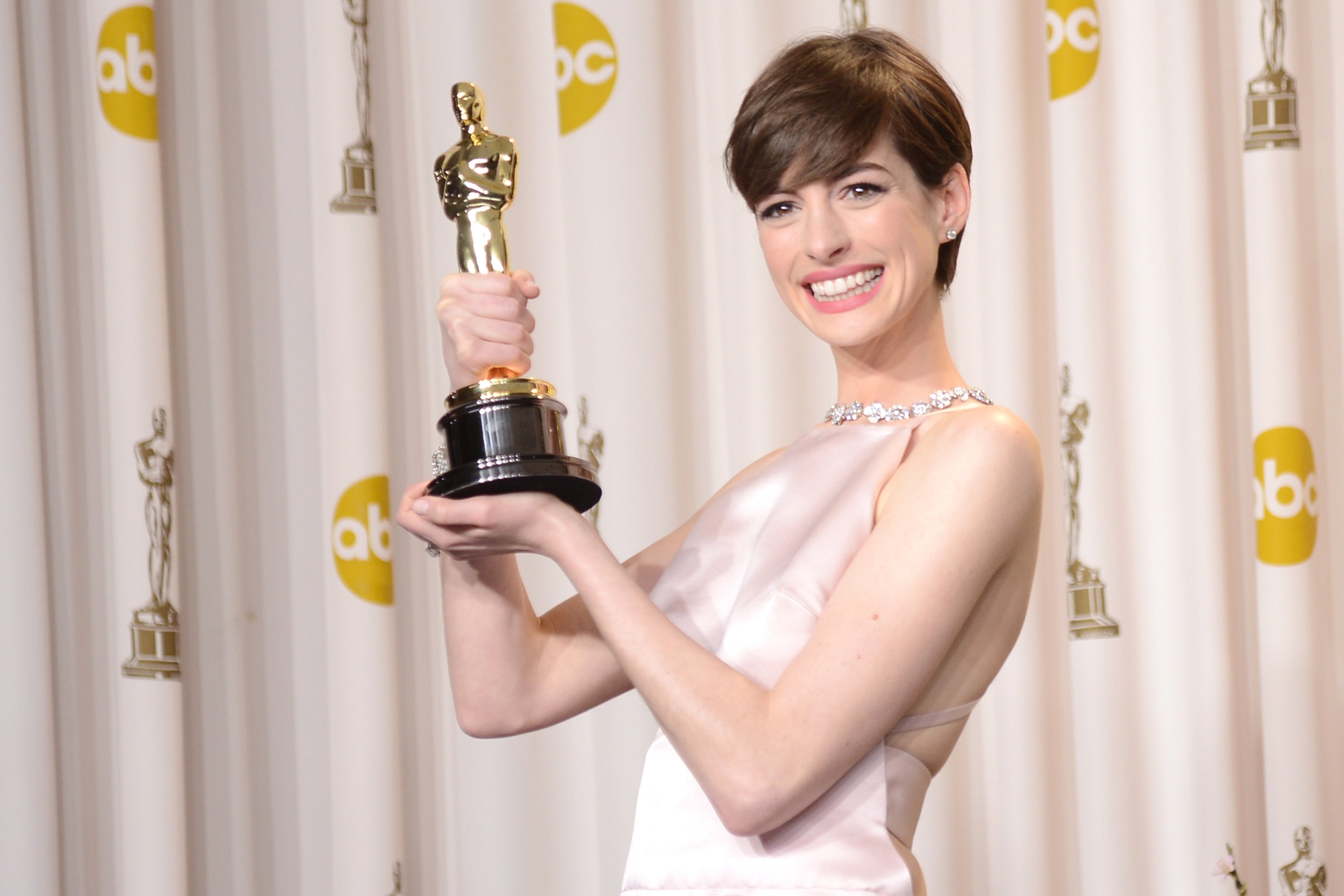 Anne Hathaway holding up her Oscar.