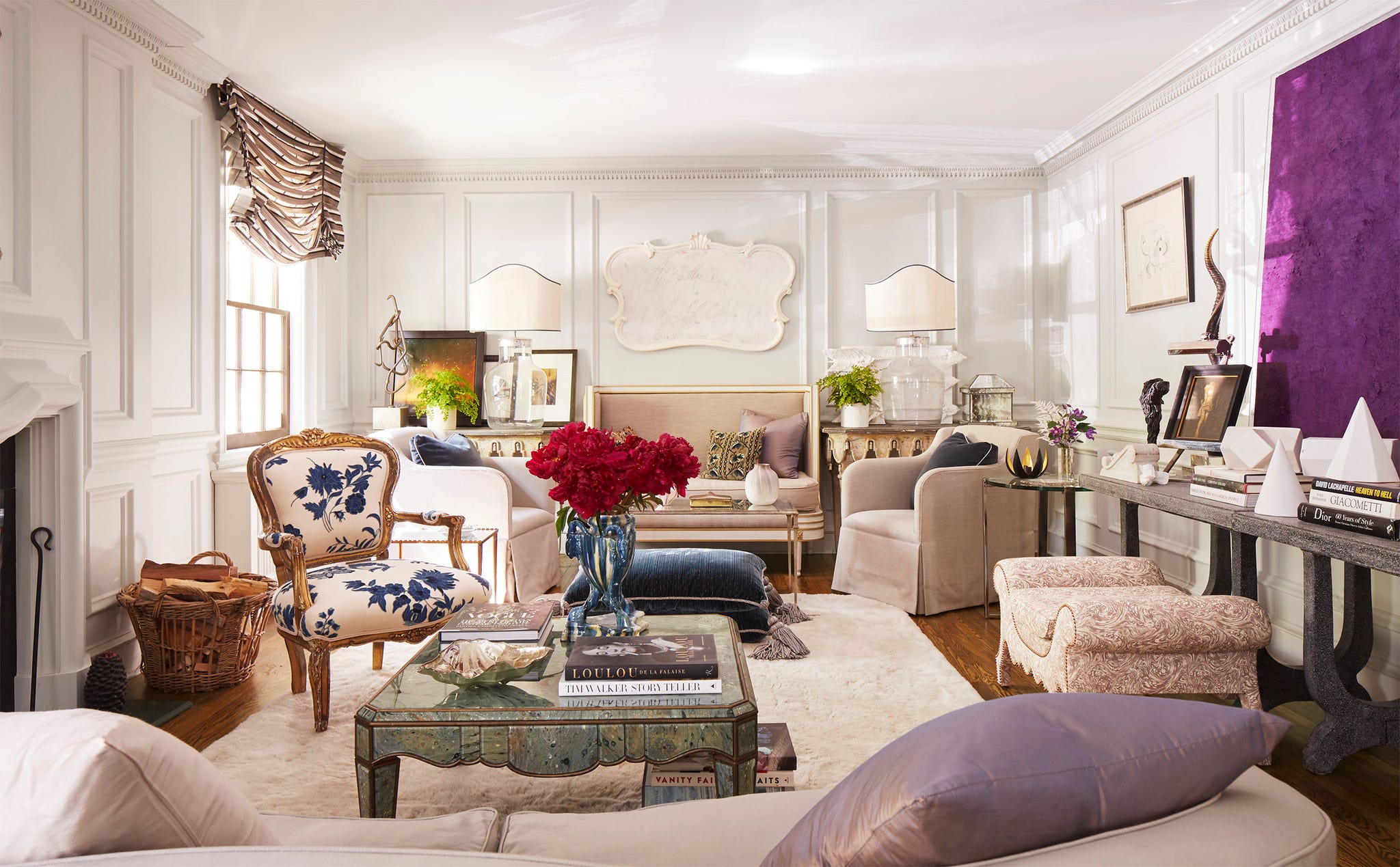 Stylishly furnished living room featuring elegant seating, decorative plants, and vibrant floral arrangements.
