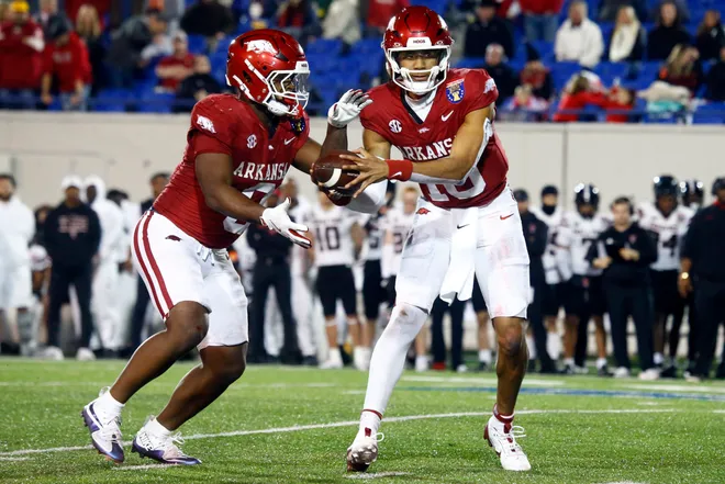 Arkansas Razorbacks quarterback Taylen Green (10) hands the ball off to Arkansas Razorbacks running back Braylen Russell