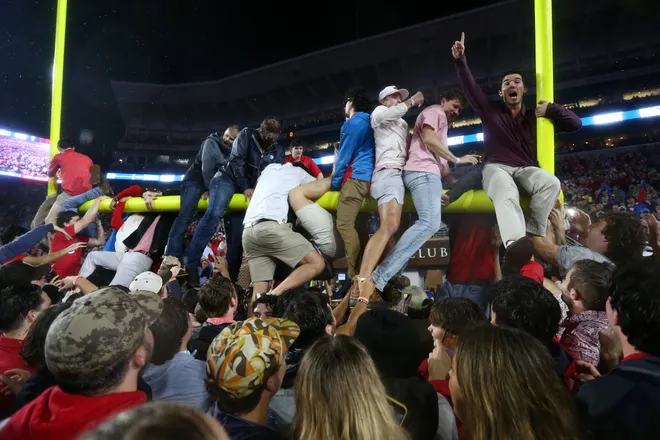 Nov 9, 2024; Oxford, Mississippi, USA; Mississippi Rebels fans attempt to tear down the goal post after defeating the Georgia Bulldogs at Vaught-Hemingway Stadium. Mandatory Credit: Petre Thomas-Imagn Images