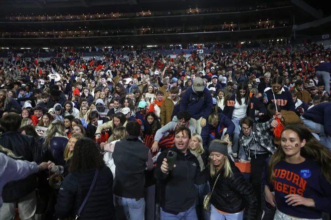 Nov 23, 2024; Auburn, Alabama, USA; Fans storm the field after the Auburn Tigers beat the Texas A&M Aggies in the fourth overtime at Jordan-Hare Stadium. Mandatory Credit: John Reed-Imagn Images