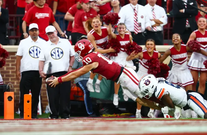 Oklahoma Sooners quarterback John Mateer dives past the Auburn Tigers