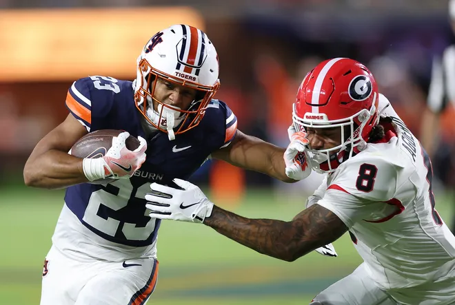 Jeremiah Cobb #23 of the Auburn Tigers rushes against Joenel Aguero #8 of the Georgia Bulldogs