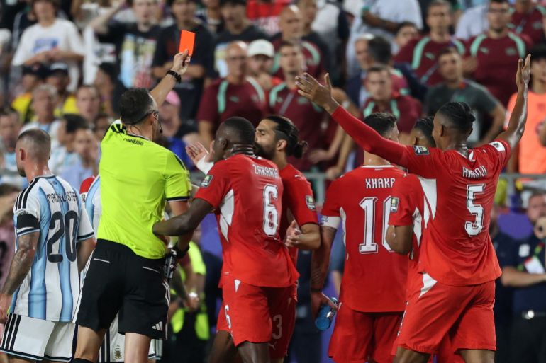 Portuguese referee Joao Pinheiro flashes a red card, after a second yellow card issued to Switzerland's forward #07 Breel Embolo (unseen) during the 2026 World Cup football tournament quarter-final match between Argentina and Switzerland at the Kansas City Stadium in Kansas City on July 11, 2026. (Photo by Thomas COEX / AFP)