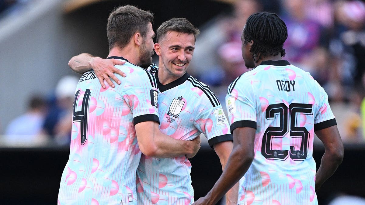 Timothy Castagne, Brandon Mechele and Nathan Ngoy celebrate after the match.