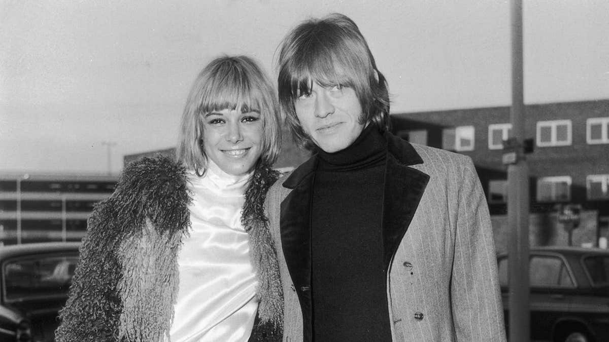 Anita Pallenberg and Brian Jones posing together outside the airport.
