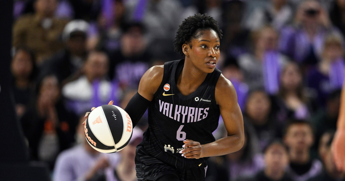 A female basketball player wearing a black "Valkyries" jersey with number 6 is dribbling a black and white basketball on court.