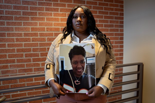 Yacarah Israel poses for a portrait holding a photo of her stepmother Sharon Israel at Lee College on May 1, 2026, in Baytown, Texas. Israel's stepmother, who raised her since she was a child, died shortly after receiving a tummy tuck procedure at 63 Laser & Skin Clinic in Chicago in 2021. (Danielle Villasana/for the Chicago Tribune)