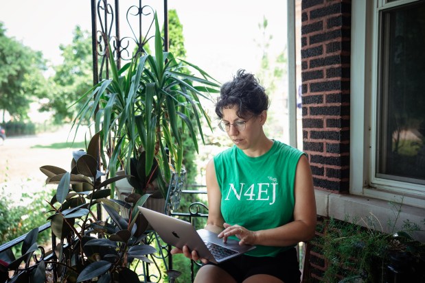 Sonia Monet Saxon, community science organizer at Neighbors for Environmental Justice, installs an air quality monitor at a home in the McKinley Park neighborhood, July 15, 2026. (E. Jason Wambsgans/Chicago Tribune)