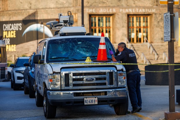 Police tape surrounds a news van while an officer works the scene where a CBS news crew was attacked near the Adler Planetarium while working Monday June 29, 2026, in Chicago. (Armando L. Sanchez/Chicago Tribune)