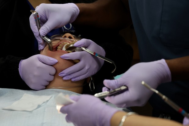 Yadhira Villegas, 17, has work done on her wisdom teeth by oral surgeon Dr. James Appiah at Oral Surgery Solutions in Chicago on June 15, 2026. (Antonio Perez/Chicago Tribune)