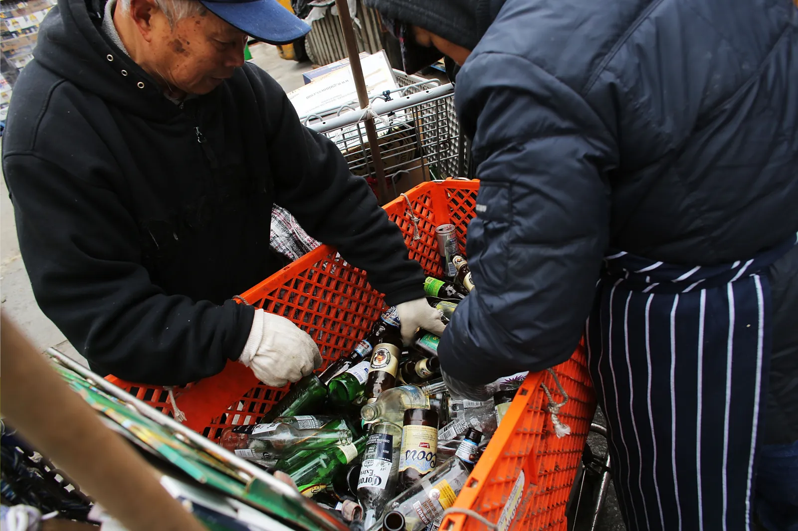 Stock image: two people sift through bottles at a redemption center in New York on February 2016.