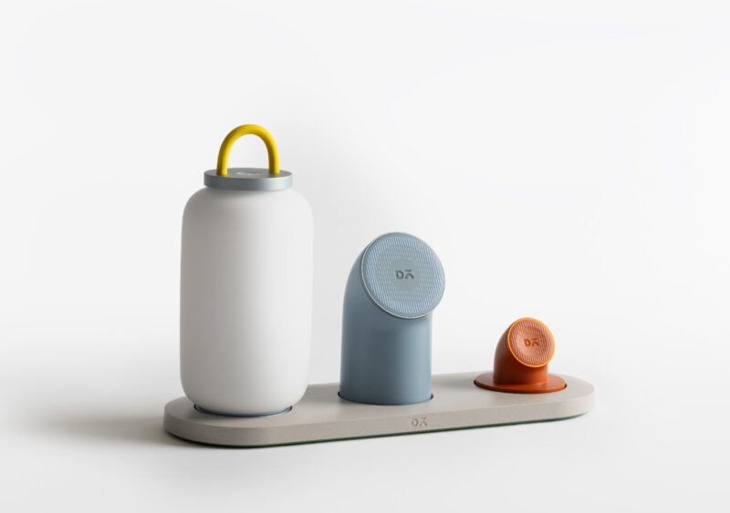 A set of three modern, minimalist kitchen containers in varying shapes and colors from DailyObjects, arranged on an oval tray against a white background.