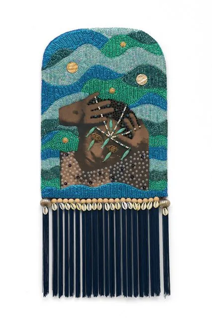 A beaded artwork features a figure holding their face amid wavy patterns in blue and green tones, adorned with shells and hanging dark blue tassels at the bottom.