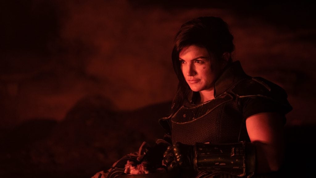 Cara Dune sitting in front of a campfire