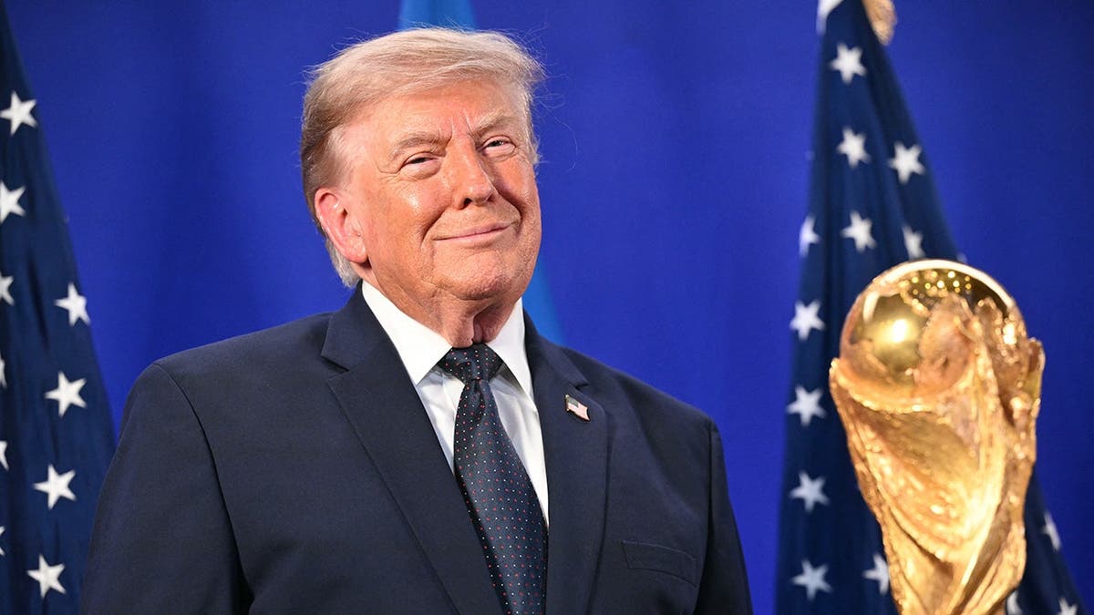 Donald Trump stands by the FIFA World Cup Trophy at Trump Tower.