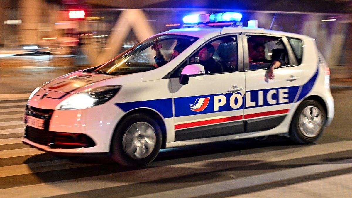 French police officers drive a car in Paris.