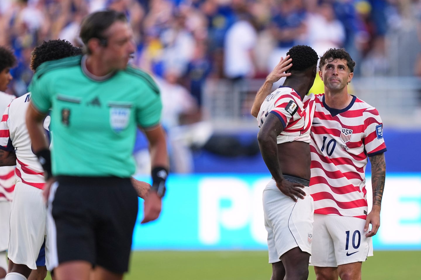US star Christian Pulisic (right) hugs striker Folarin Balogun (center) after he received a red card on Wednesday.