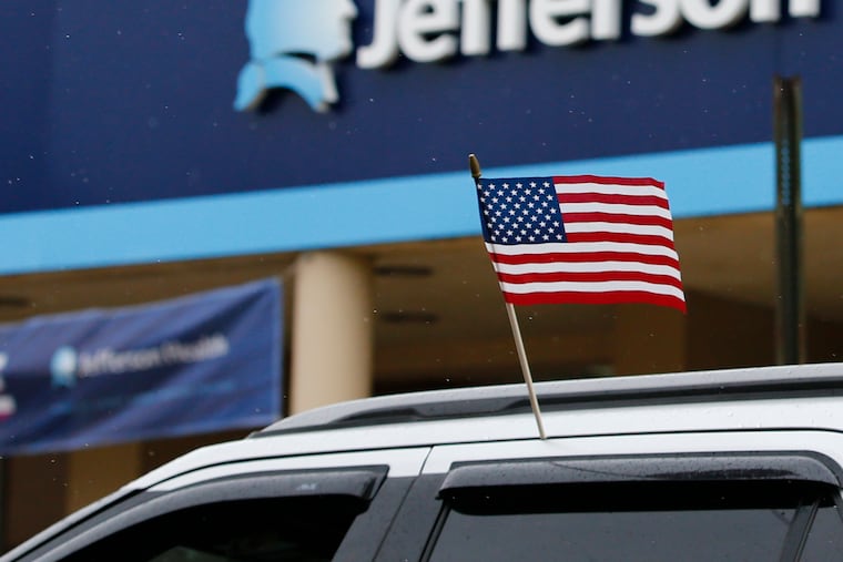 A car with the American flag passes Methodist Hospital-Jefferson Health during a Reopen Philly caravan on South Broad Street in South Philadelphia on Friday, May 8, 2020.