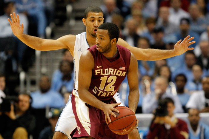 Jeff Peterson of the Florida State Seminoles looks to pass while a defender guards him.