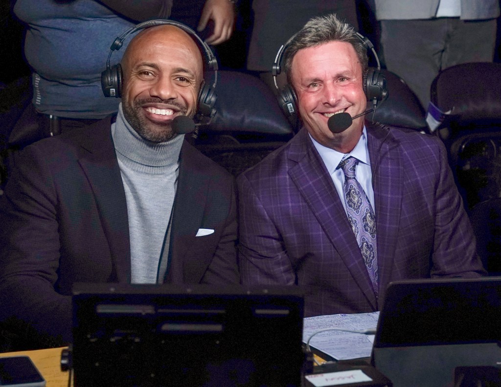 Two male sports commentators smiling with headsets and microphones.