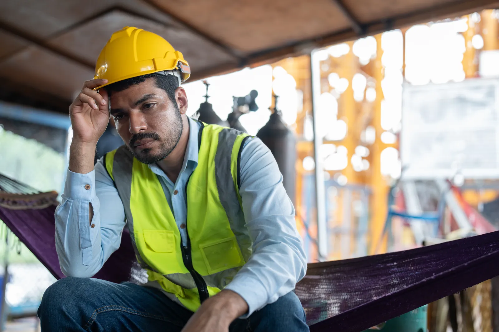 Stock image: a man looks tired and unmotivated while working at a construction site.