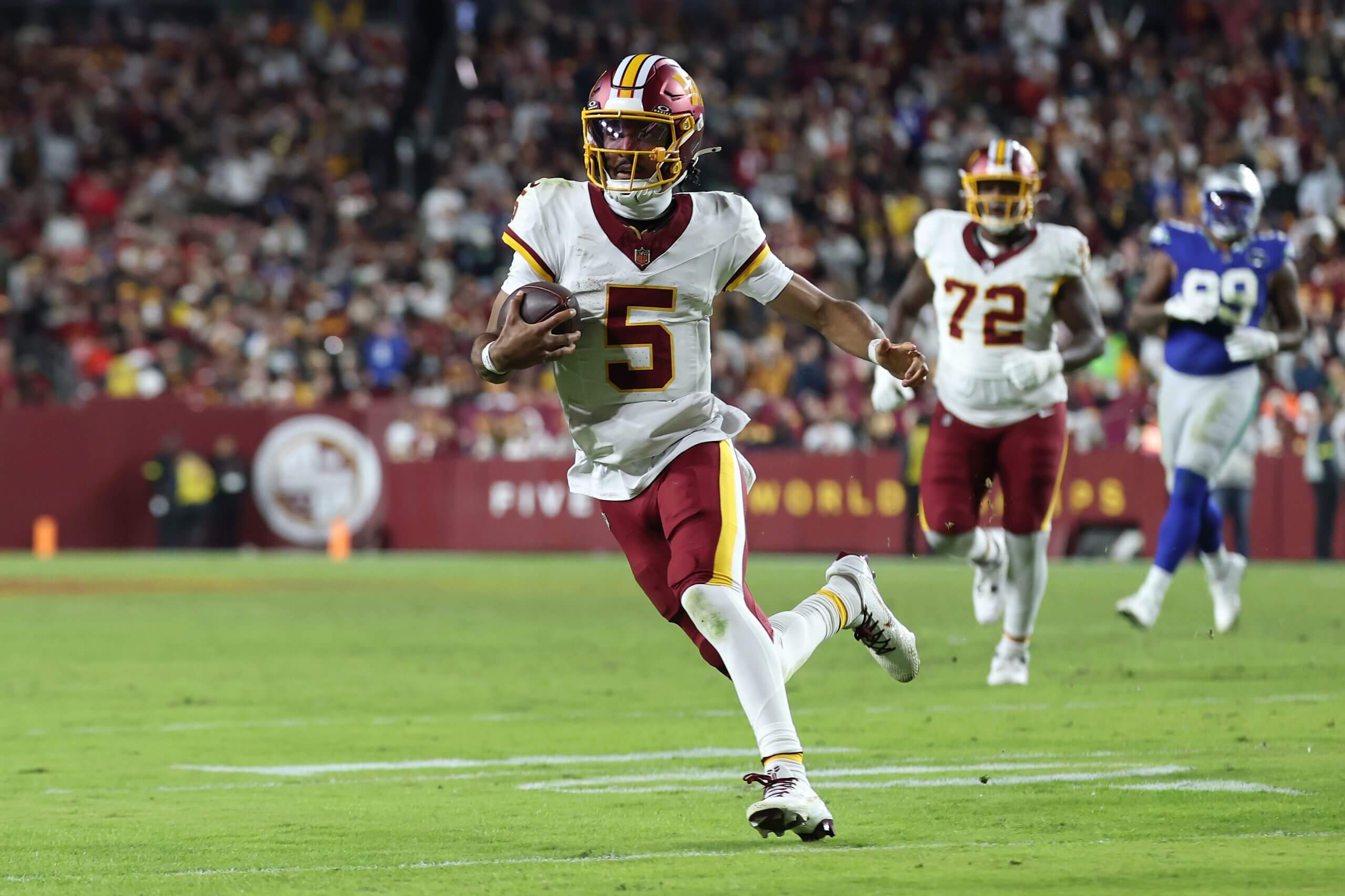 Jayden Daniels runs with the ball in a game.