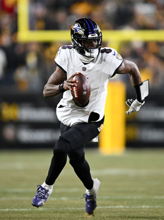 Lamar Jackson runs with the ball.