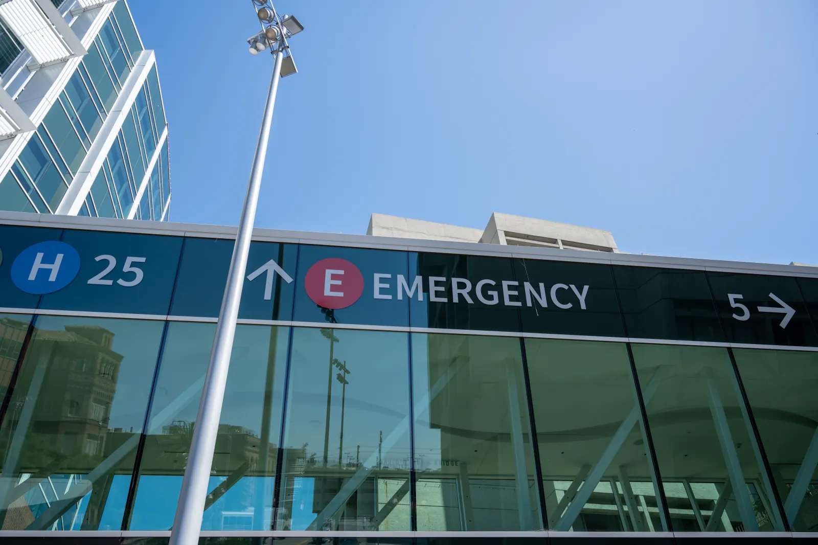 Exterior of modern hospital building with large glass windows and emergency department signage on a clear day, San Francisco, California, May 20, 2026.