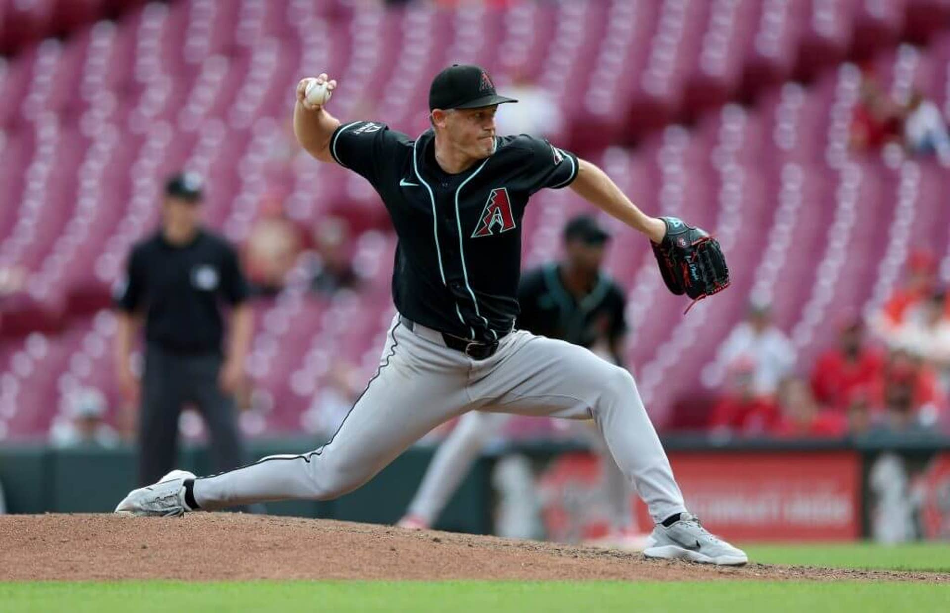 Paul Sewald clad in a navy Diamondbacks' uniform with gray pants prepares to pitch with the ball in his right hand.