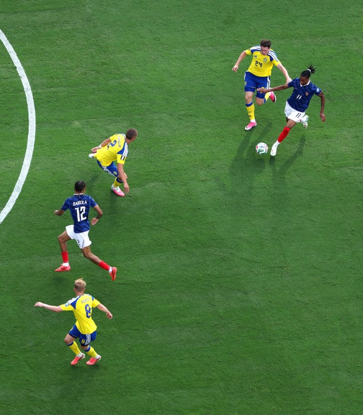Michael Olise of France controls the ball under pressure from Elliot Stroud of Sweden during the FIFA World Cup 2026 Round Of 32 match between France and Sweden.