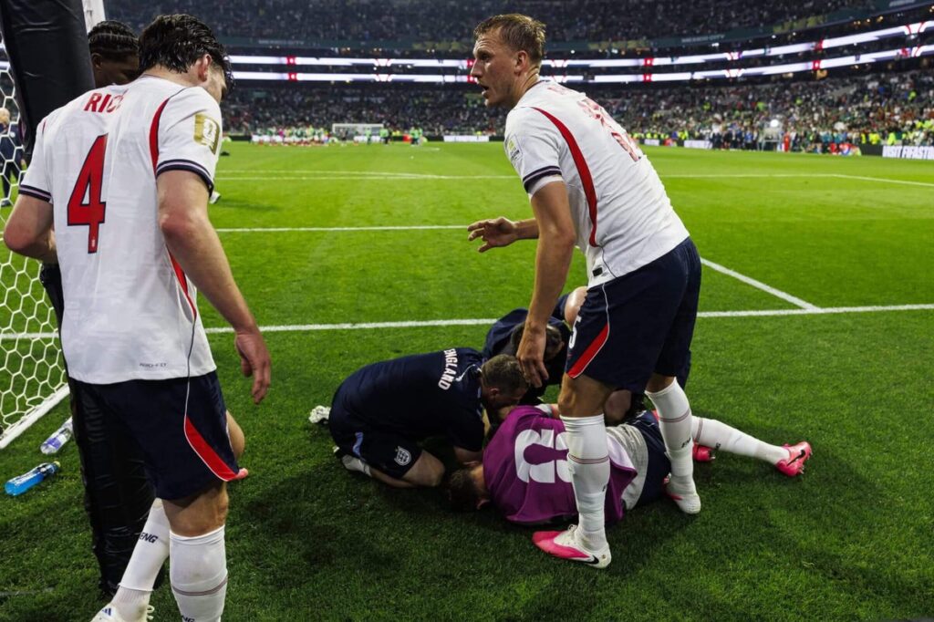 Declan Rice (L) and Dan Burn of England (R) try to help their teammate Jordan Henderson