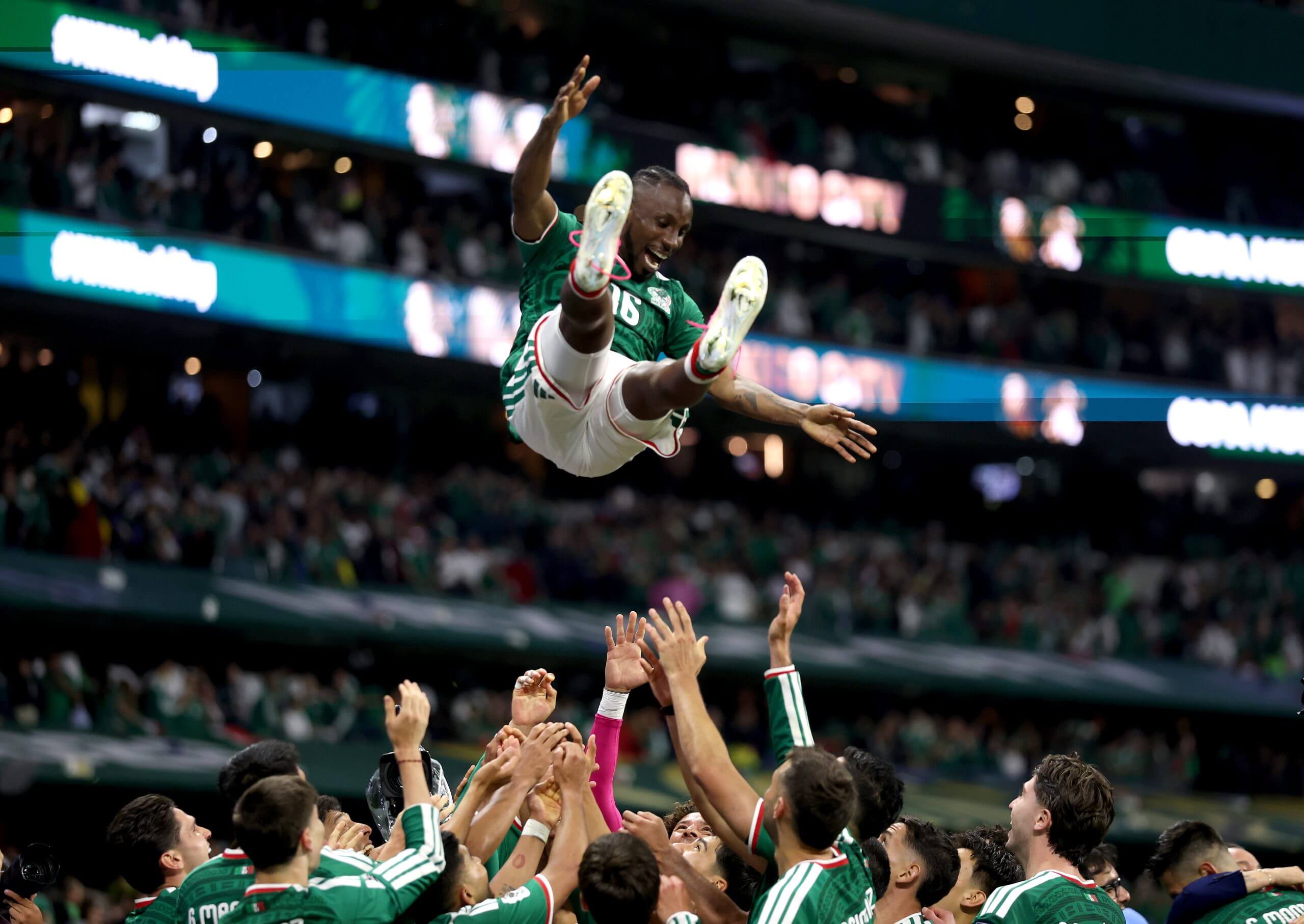 A Mexican player is thrown into the air by teammates
