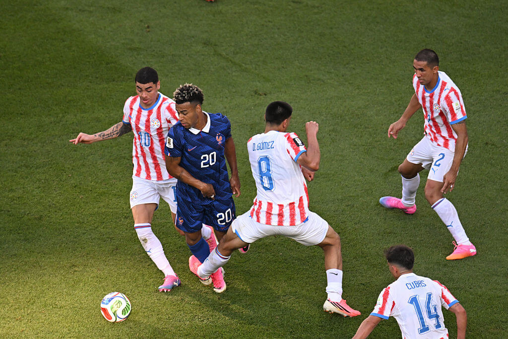 Paraguay's Diego Gomez trips France's Desire Doue with his left leg