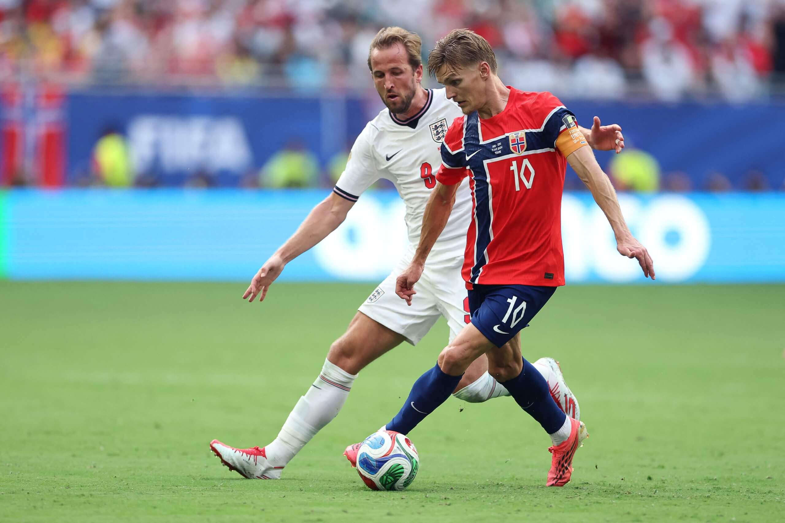 Martin Odegaard shields the ball from Harry Kane