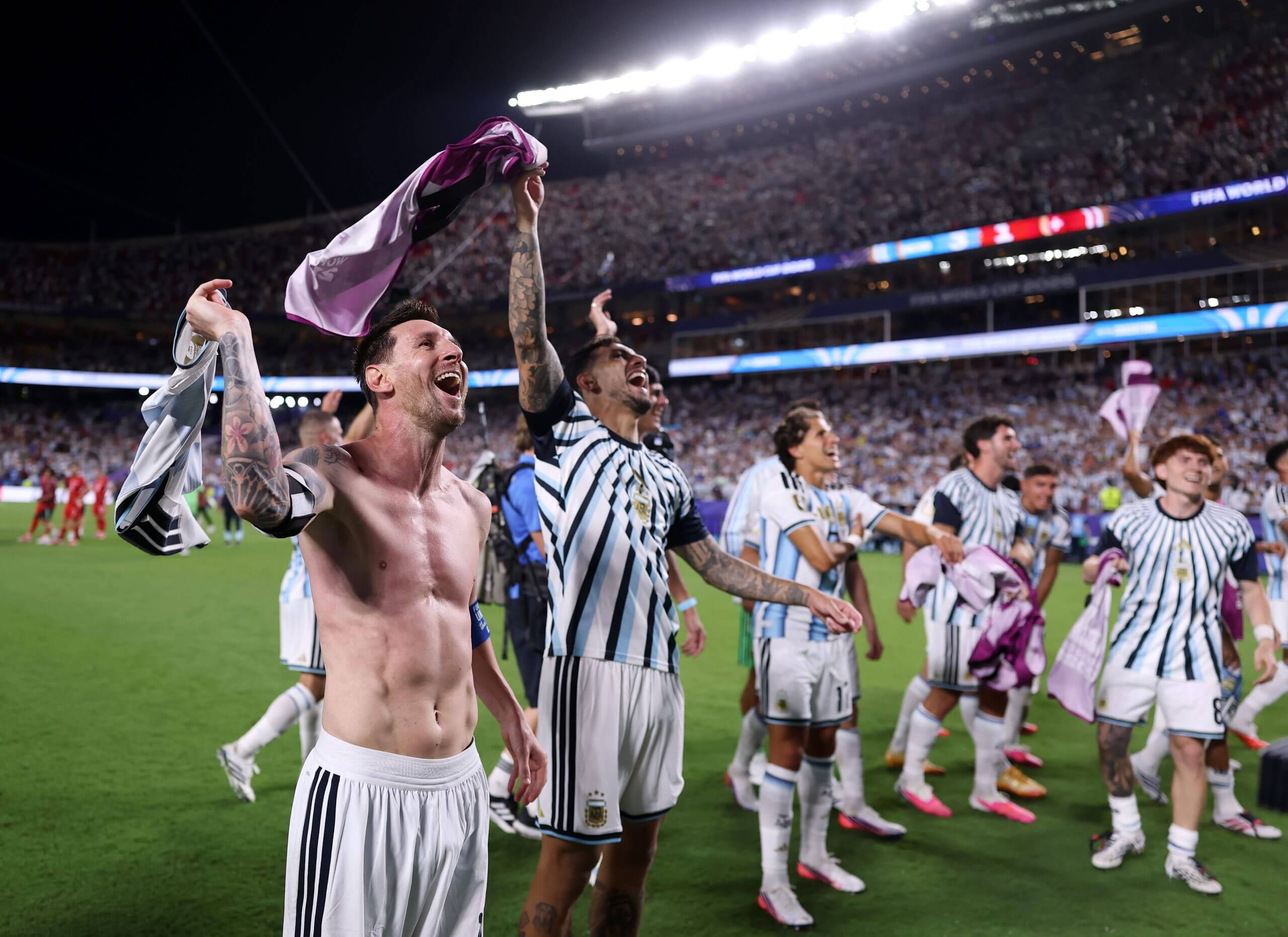 Argentina players twirl their shirts above their heads in celebration