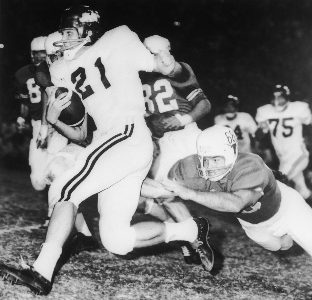 Jim Lindsey (21) Arkansas back gallops for eight yards before Texas' Barney Giles (68) made a dive to trip him up in the first quarter