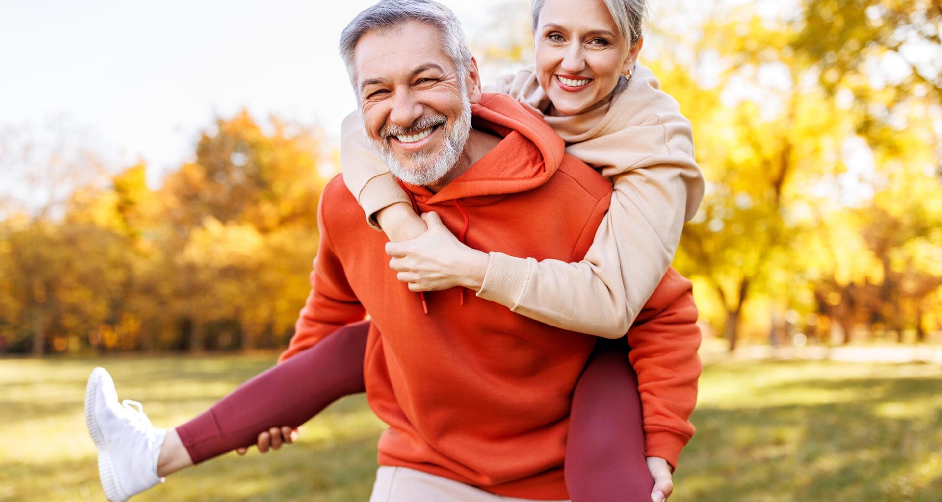 Happy Senior Couple Smiling Piggyback Park Fall Fitness