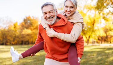 Happy Senior Couple Smiling Piggyback Park Fall Fitness
