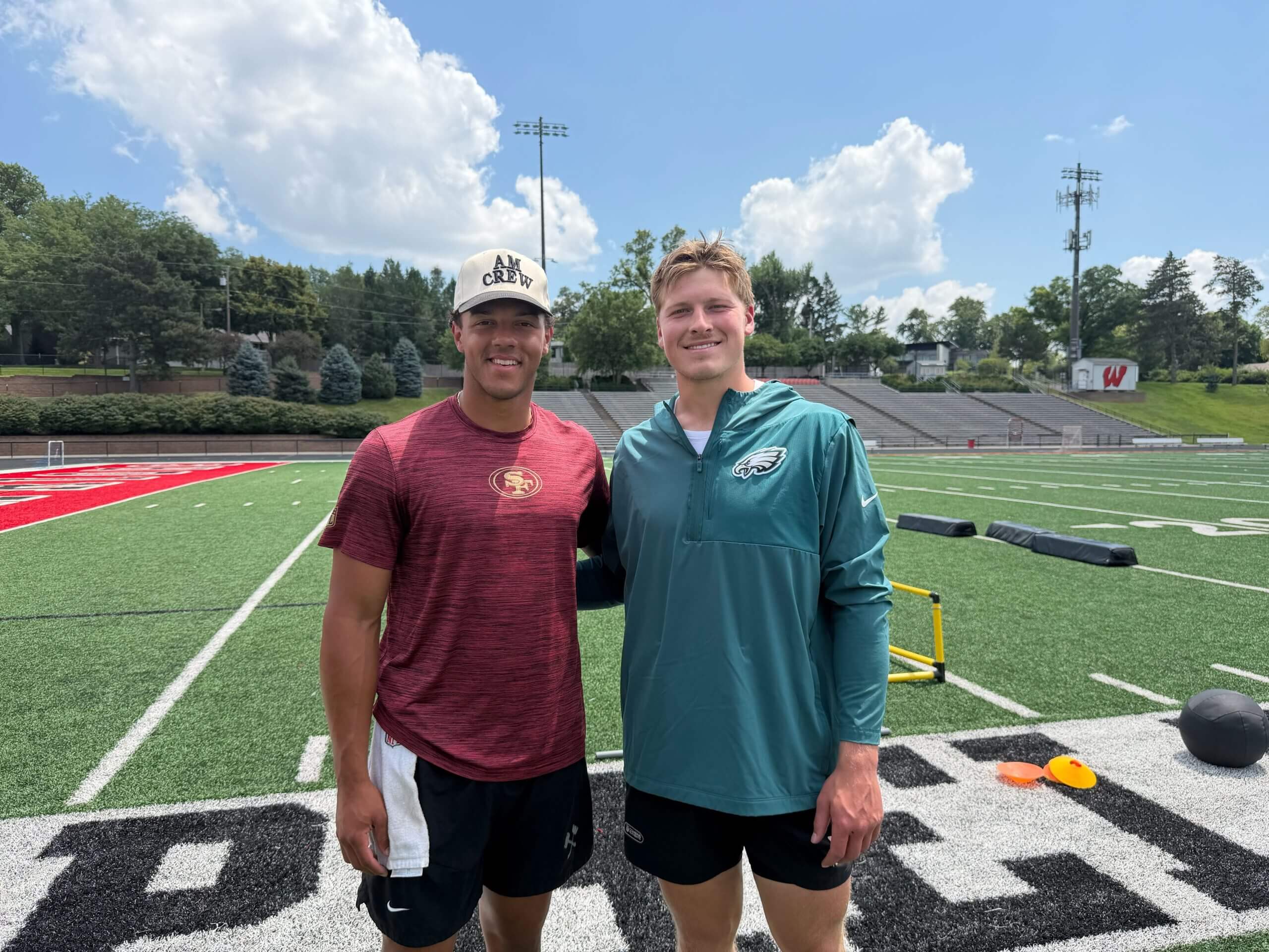 Adrian Martinez, left, and Cole Payton smile on a high school football field.