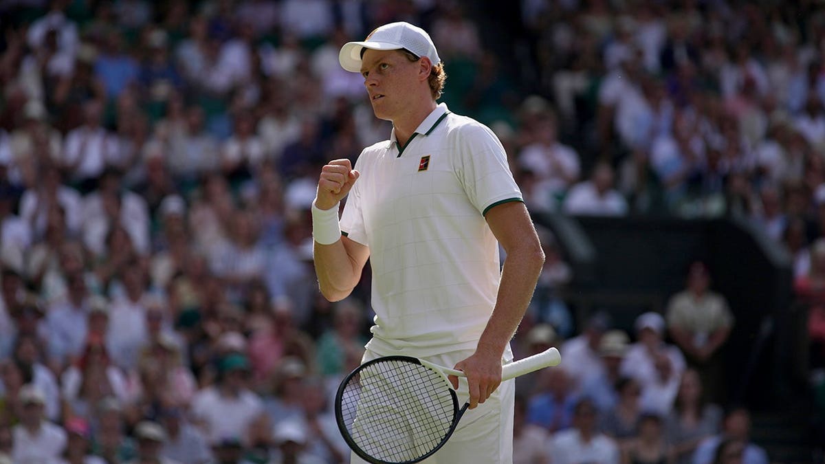 Jannik Sinner celebrates a point against Novak Djokovic on the Wimbledon court.