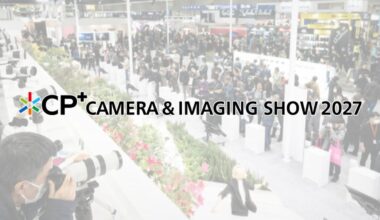 Crowds walk through a busy camera expo with photographers using large lenses. Text reads: "CP+ Camera & Imaging Show 2027." Bright, modern indoor setting.