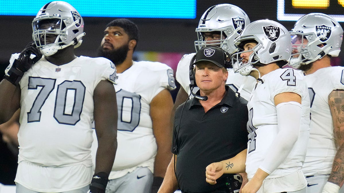 Las Vegas Raiders head coach Jon Gruden talks with quarterback Derek Carr (4) during the second half against the Los Angeles Chargers at SoFi Stadium.