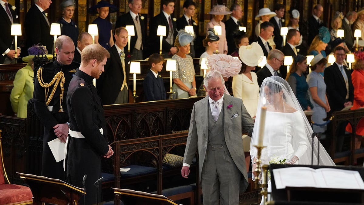 The former Prince Charles walking Meghan Markle down the aisle on her wedding day.