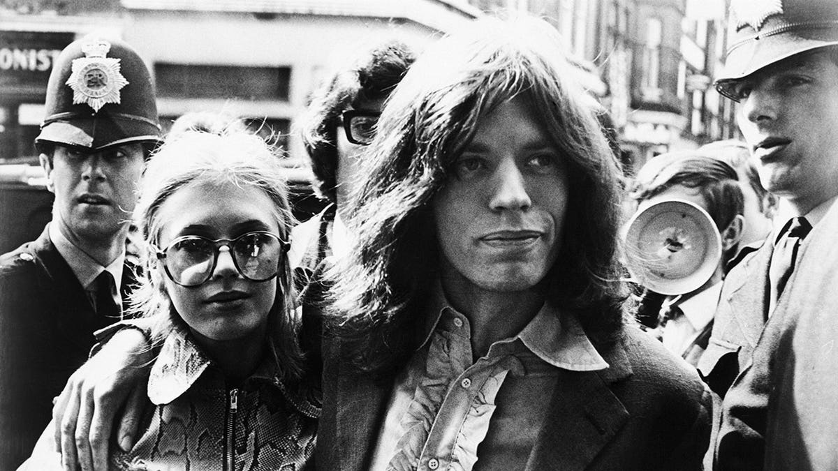 Mick Jagger embracing Marianne Faithfull outside of court.