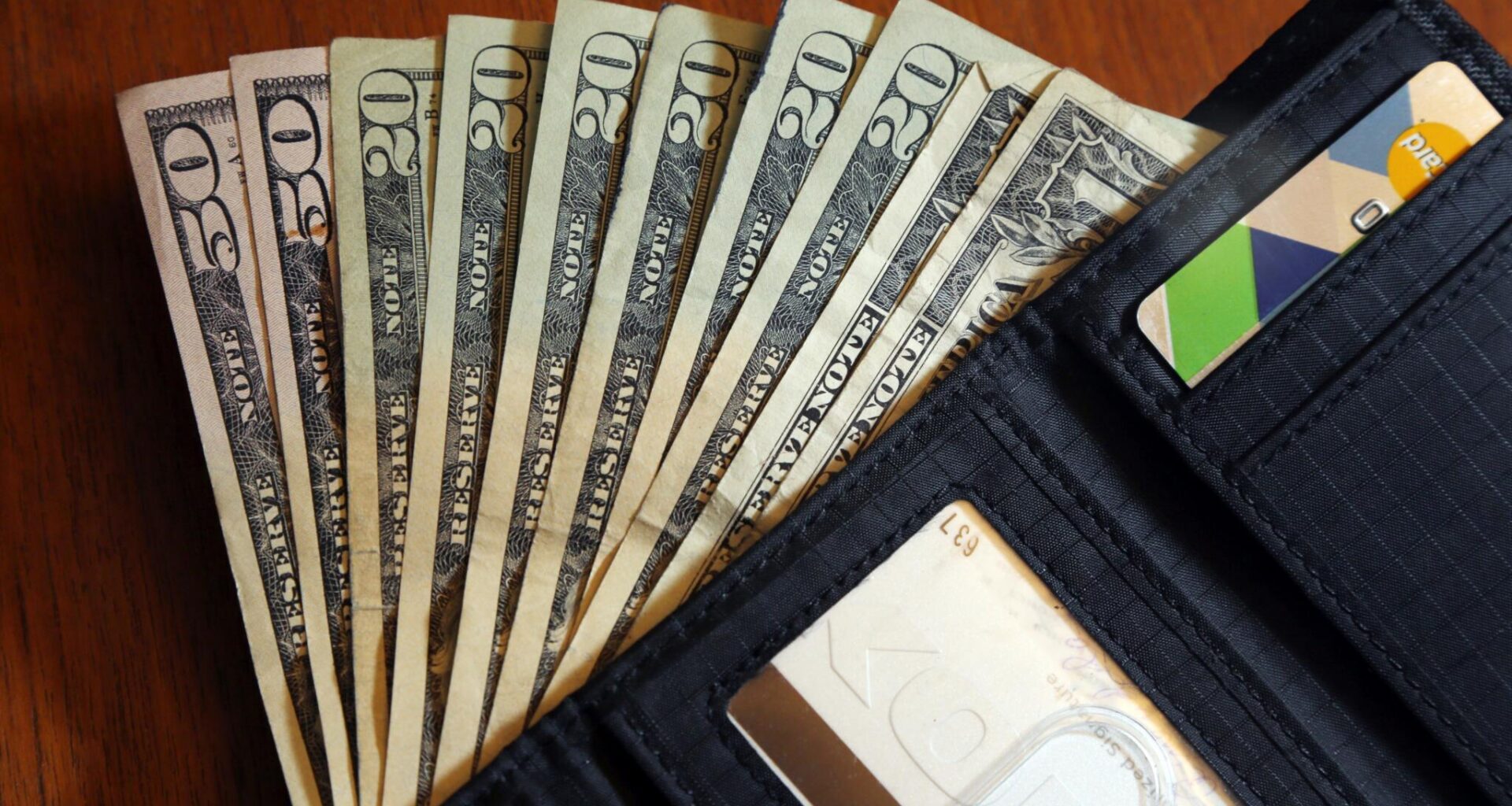 Cash is fanned out from a wallet in North Andover, Mass, June 15, 2018. (Elise Amendola/AP Photo)