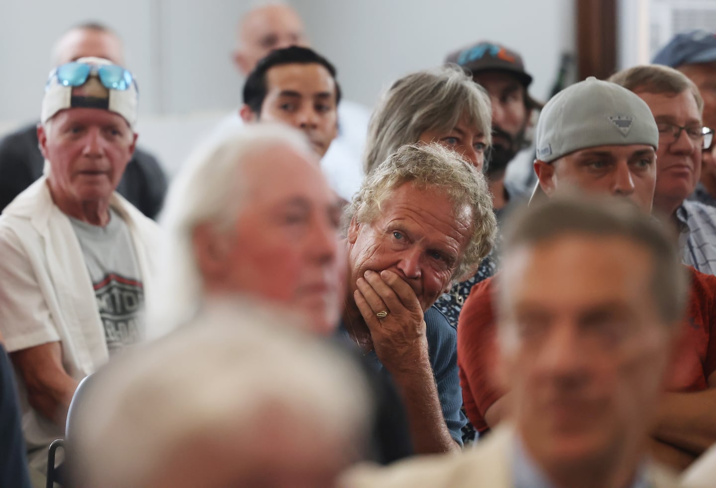 A man listened during a public meeting after a sewer break forced the closure of clamming flats.