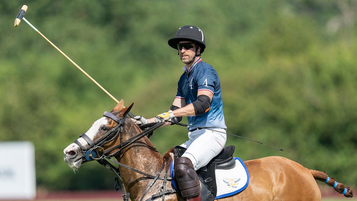 Prince William stands on a polo field in Windsor, England.