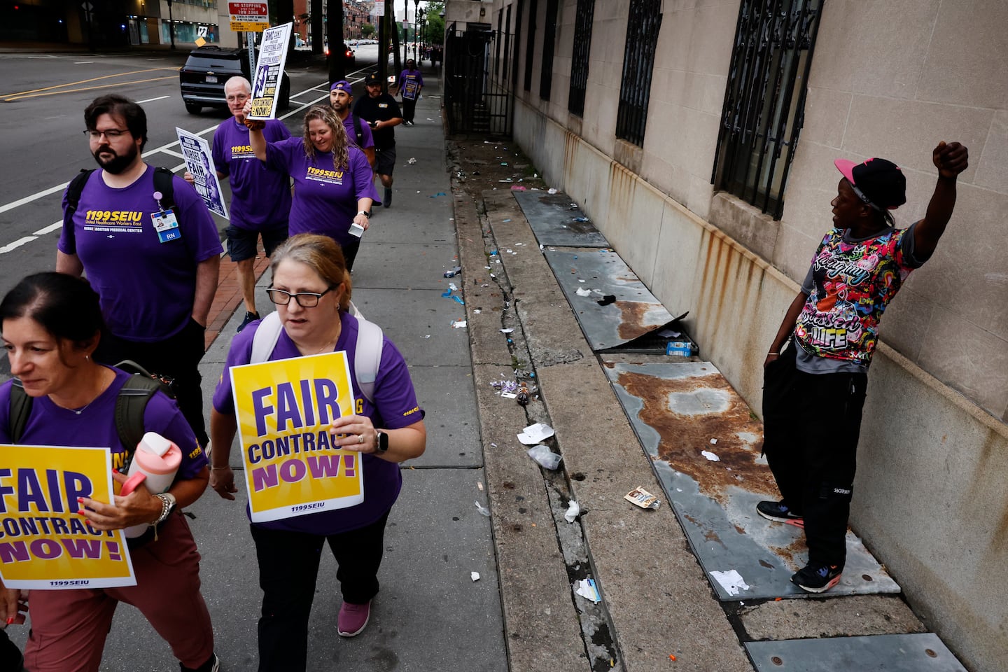 A woman named Malichi raised her fist in support of nurses at Boston Medical Center as they picketed Wednesday.