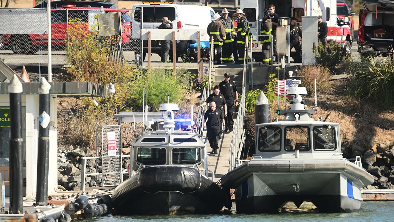 Emergency crews gather at a dock near the site of a pontoon boat fire on Tuesday, July 14, 2026, in San Francisco. (AP Photo/Noah Berger)